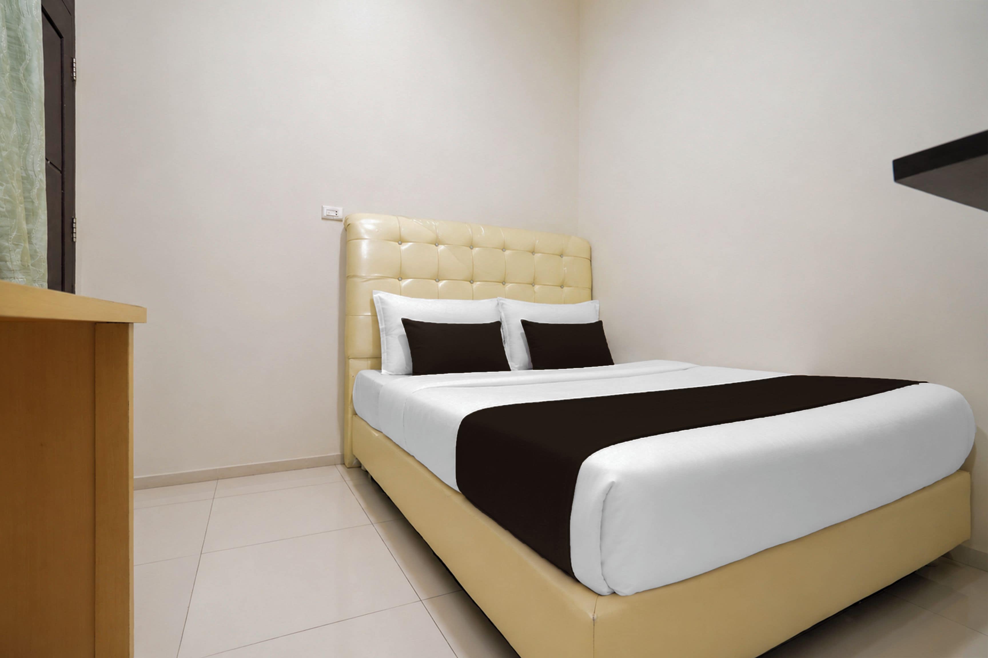 Un dormitorio con una cama, una mesita de noche y una estantería en la pared.