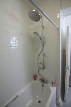 Ein Badezimmer mit Badewanne, Duschkopf und Handbrause.