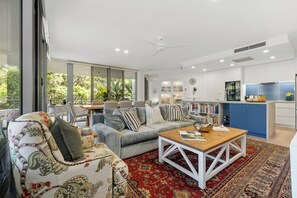 Ein modernes Wohnzimmer mit Sofa, Couchtisch und einem Essbereich mit Stühlen.
