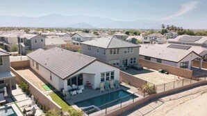 A residential area with houses, a swimming pool, and a clear view of distant mountains. - Saltwater Pool, Spa & Casita  Terra Lago (Indio)