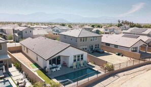 A residential area with houses, a swimming pool, and a clear view of distant mountains. - Saltwater Pool, Spa & Casita  Terra Lago (Indio)