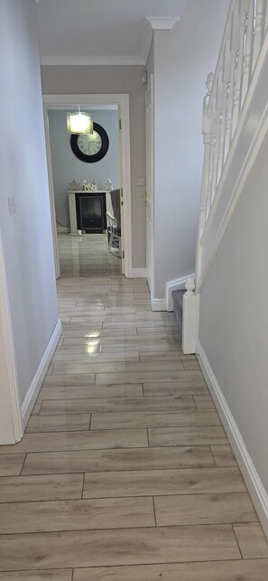A hallway with a wooden floor, white walls, and a staircase with white balusters. - King size bed ensuite bathroom wifi near university hospital Birmingham (Birmingham)