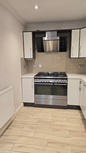 A modern kitchen with a gas stove, oven, and stainless steel cabinets. - King size bed ensuite bathroom wifi near university hospital Birmingham (Birmingham)