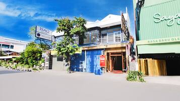 A street view with a building labeled "ISAQ CENTER" and another building with a sign "SAYA RASA BARU OLE".