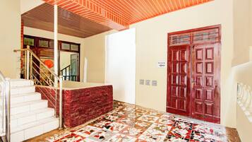 A staircase with a red carpet leading to a white door marked "MASUK".