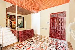 A staircase with a red carpet leading to a white door marked "MASUK".
