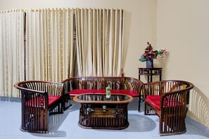 A living room with a sofa set, a coffee table, and a side table with a vase of flowers.