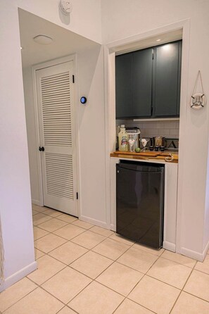 A compact kitchen with a dishwasher, a microwave, and a small countertop with various items. - Villa Bandido-Golf Course, Pool, Tennis Court, Pet Friendly, & Golf Cart Deals (Miramar Beach)
