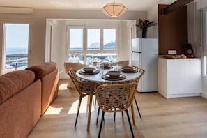 A modern kitchen with a dining area, large windows, and a view of the sea. - Geure portue etxea, wonderful sunrise (Bermeo)