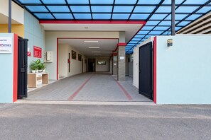 A hallway with a glass ceiling, red and white walls, and a sign indicating a cafe. - Collection O near Taman Semanggi (Jakarta)