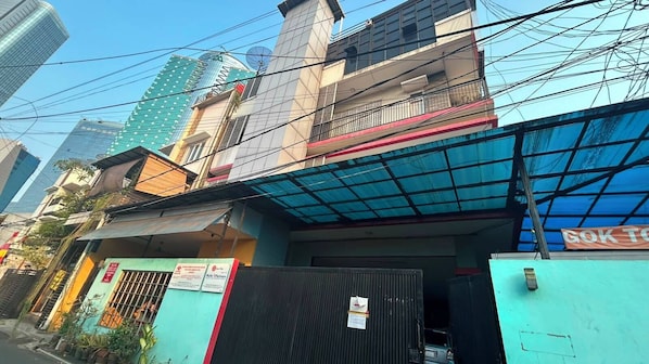 A multi-story building with a gated entrance, a blue awning, and a sign that reads 'GOK TO'.