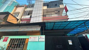Un edificio de varios pisos con escaparate verde y cartel de cafetería.