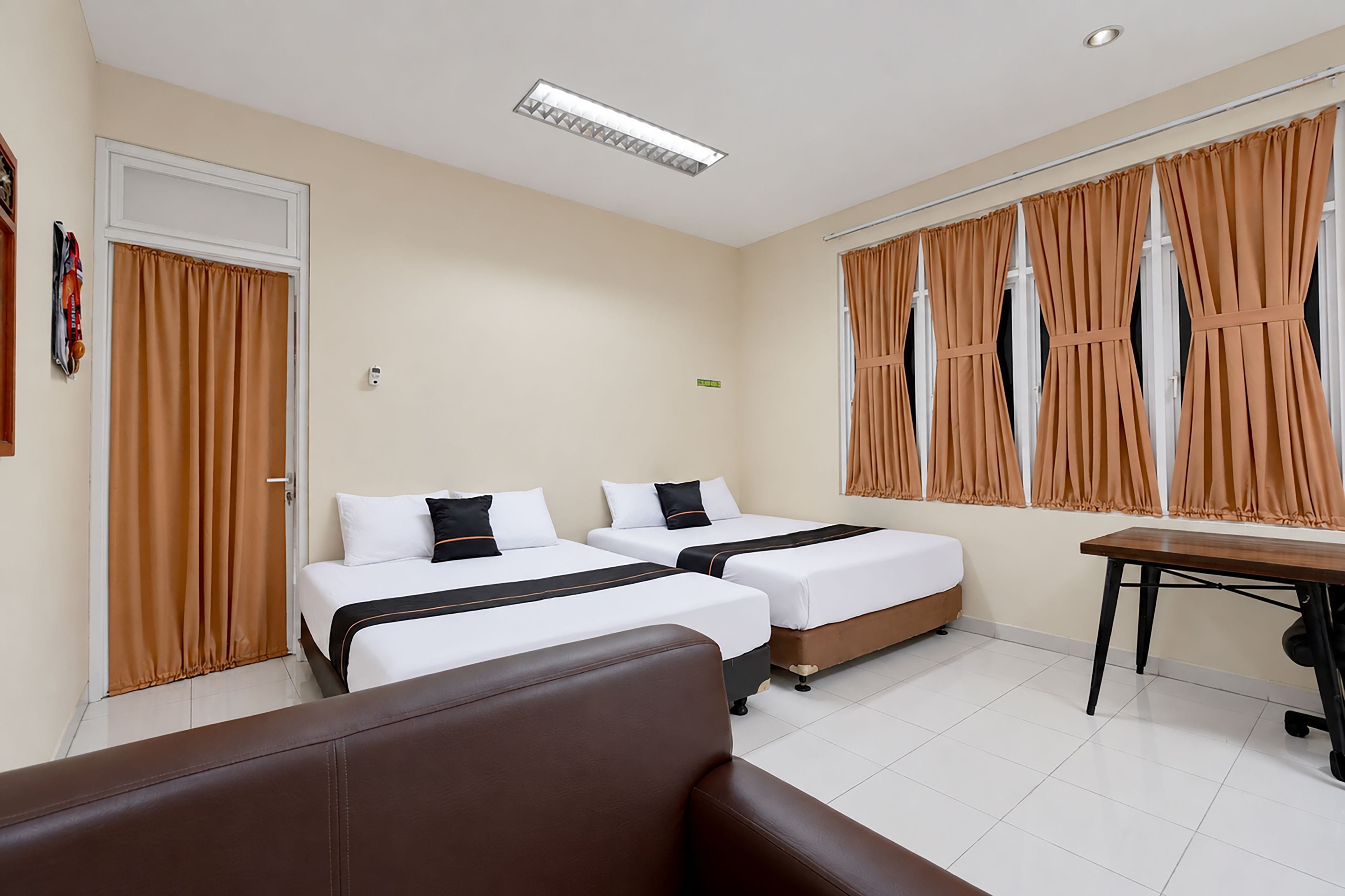Una habitación de hotel con dos camas, un escritorio y una silla.