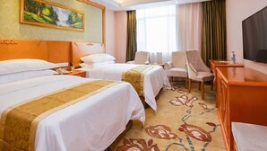 A hotel room with two beds, a desk, a chair, a television, and a painting on the wall. - Vienna Hotel (Nanjing)