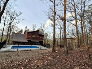 A cabin with a pool, surrounded by trees. - Three Bears Cabin | Included Heated Pool, Hot Tub & Mountain Views Near Hochatown | Pet-Friendly (Broken Bow)