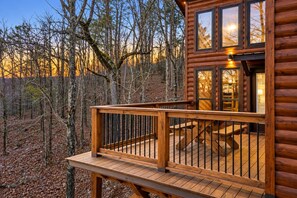 A wooden cabin with a deck and a dining area. - Three Bears – Mountainside Cabin with Private Heated Pool & Hot Tub (Broken Bow)