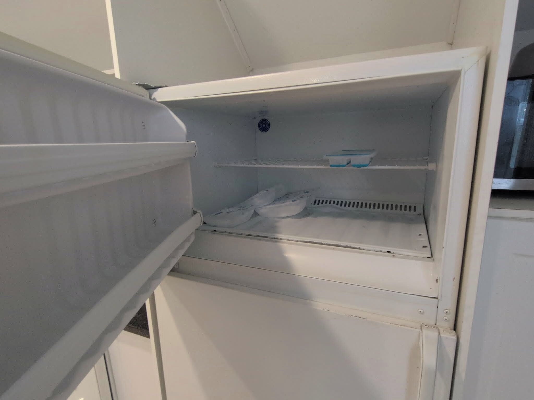 An open refrigerator with shelves and a freezer compartment.