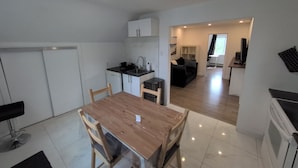A compact living space with a dining area, kitchenette, and a living room.