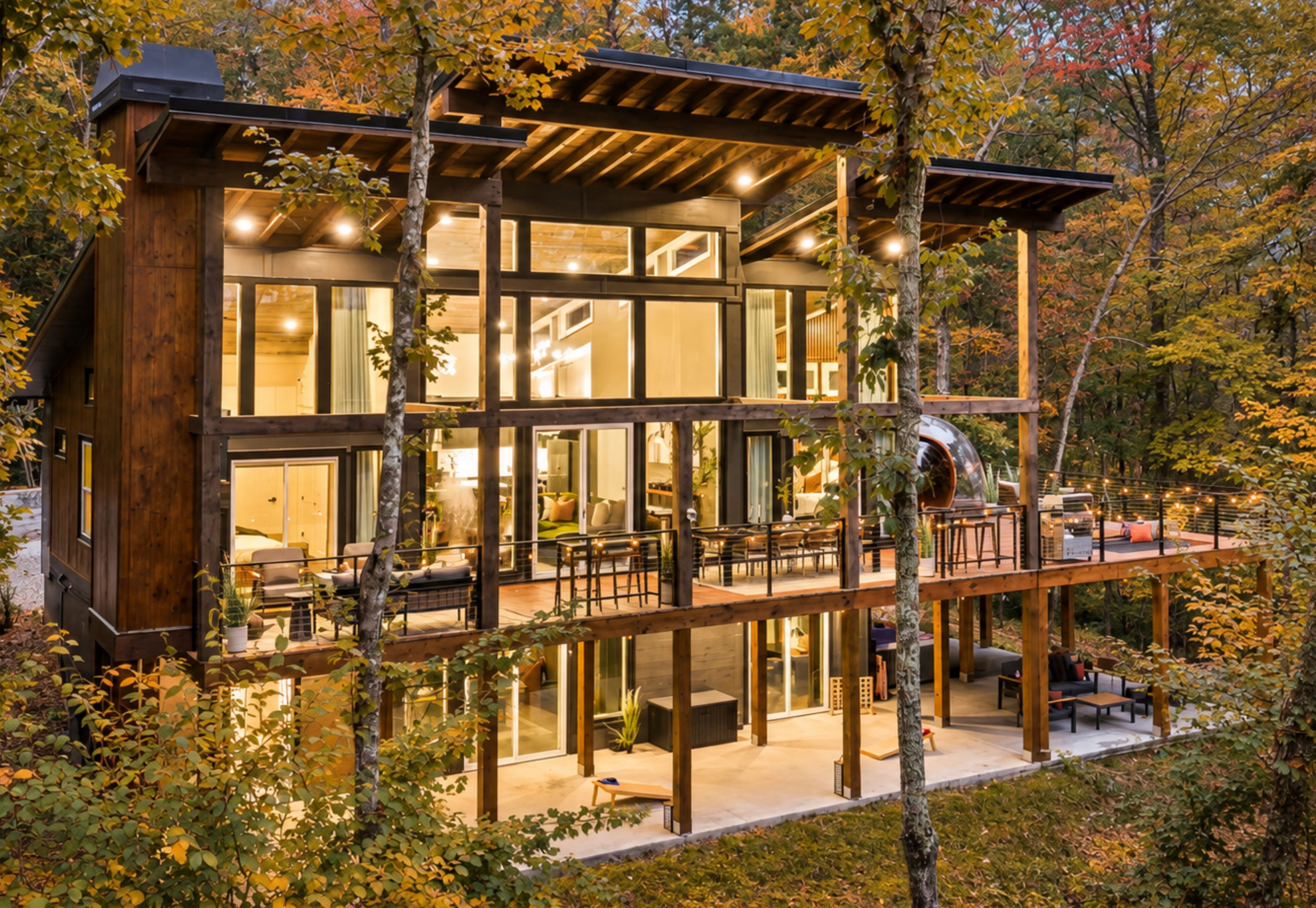 Eine mehrstöckige Holzhütte mit großen Fenstern, einem Balkon und einer Terrassenfläche.