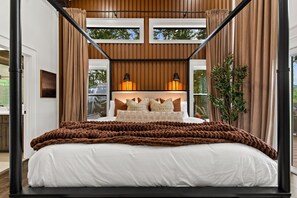 A modern bedroom with a four-poster bed, a large window, and a view of the outdoors. - Bluebird Reserve: Dome • Sauna • Hot-Tub • Cold Plunge • Fire-Pit • Putt • Views (Mineral Bluff)