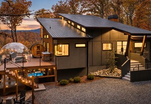 As golden hour settles over Bluebird Reserve, every light begins to glow, and so does the feeling that you've arrived somewhere special. - Bluebird Reserve: Dome • Sauna • Hot-Tub • Cold Plunge • Fire-Pit • Putt • Views (Mineral Bluff)