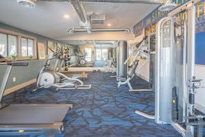 A gym with treadmills, elliptical machines, and weight equipment.