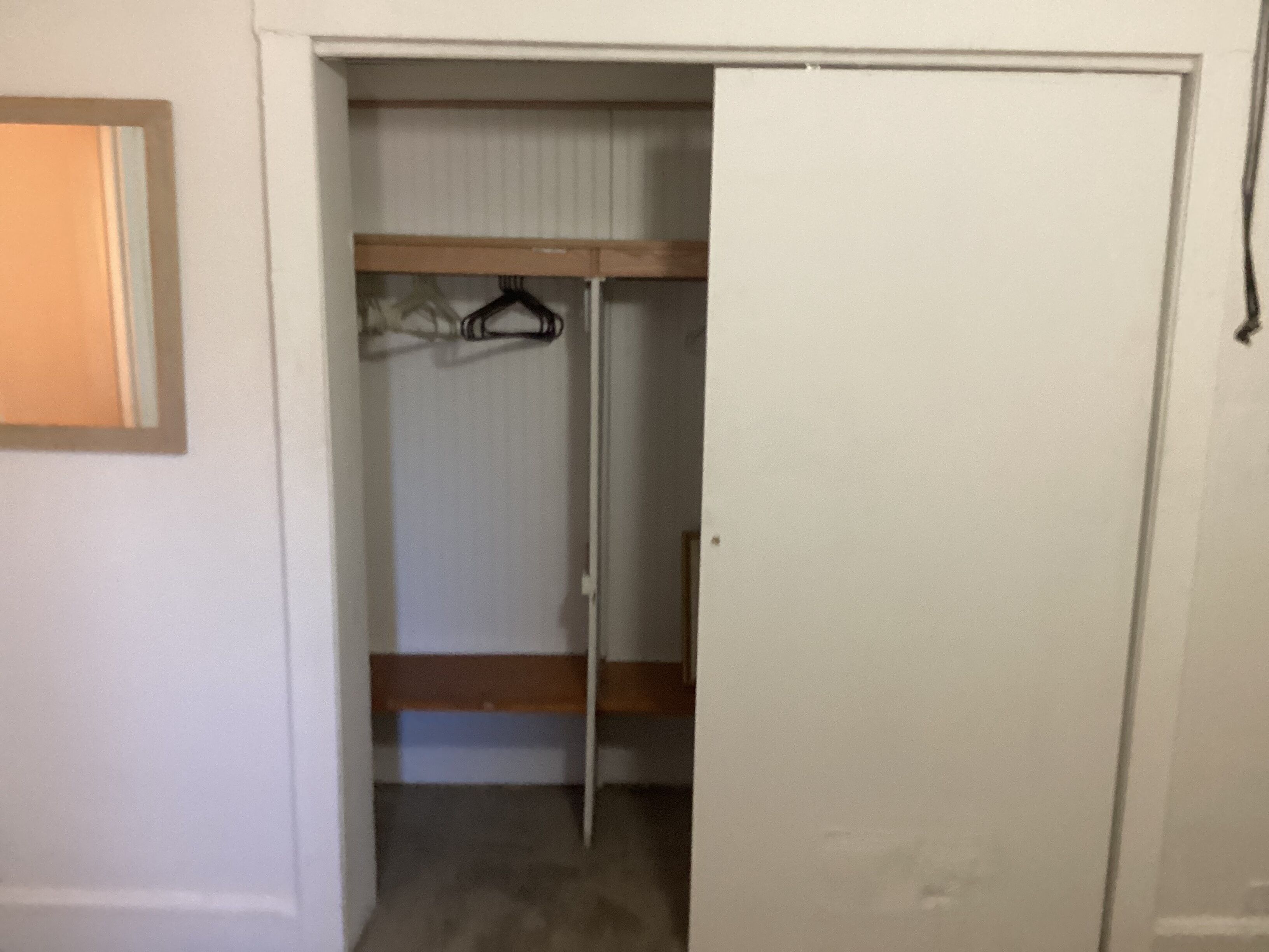 Porta fechada de um quarto com beliche e cabide.