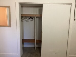 A closed door to a room with a bunk bed and a hanging coat rack.