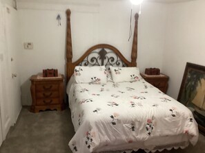 A bedroom with a wooden four-poster bed, floral bedding, two bedside tables, and a framed picture on the wall. - Cozy 1-bedroom apartment in beautiful Albuquerque with AC private gated parking (Albuquerque)