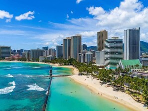A coastal cityscape with a beach, high-rise buildings, and a clear sky. - Charming Waikiki Studio, Kitchenette+Walk to Beach (Honolulu)