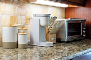 A kitchen with a coffee maker, a toaster, and a knife block on a granite countertop. - Charming Waikiki Studio, Kitchenette+Walk to Beach (Honolulu)