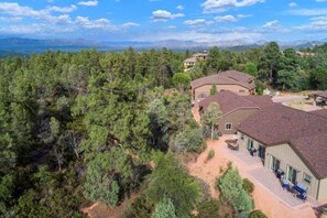 A large house surrounded by dense forest with a clear sky. - Peaceful 3BR Getaway | Pines, Wildlife, Hiking & Golf (Payson)