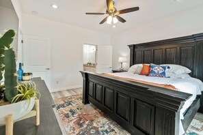 A bedroom with a large bed, a ceiling fan, and a rustic rug. - Peaceful 3BR Getaway | Pines, Wildlife, Hiking & Golf (Payson)