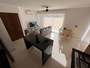 Eine moderne Küche mit Essbereich, einem Fernseher und einem großen Fenster.