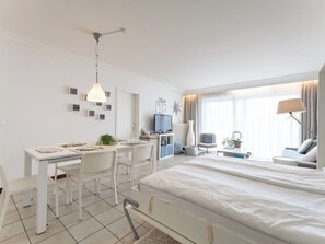 Ein modernes Hotelzimmer mit Bett, Schreibtisch, Stühlen und Fernseher.