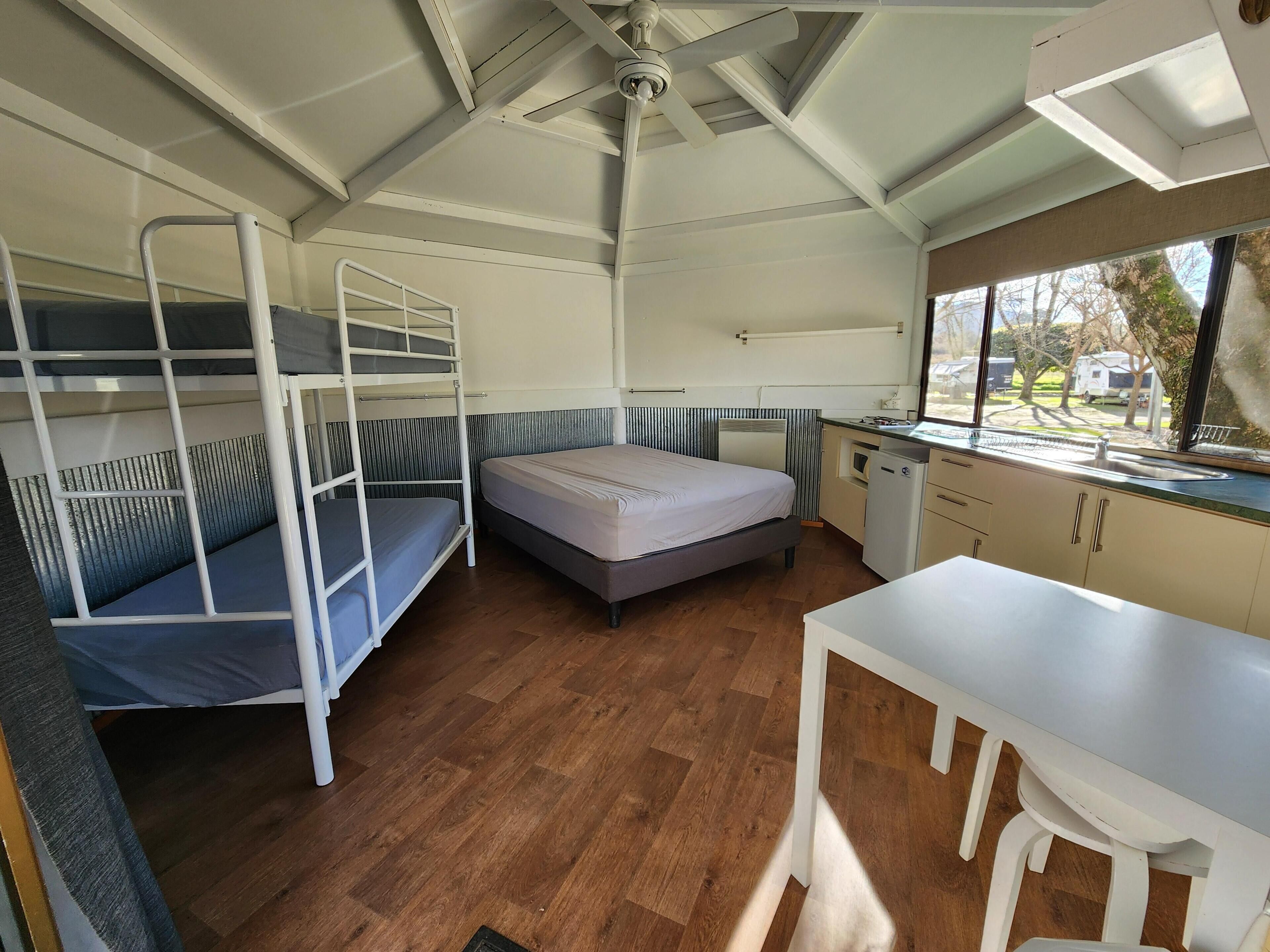 Una habitación compacta con literas, un pequeño kitchenette y una ventana que ofrece vistas al exterior.
