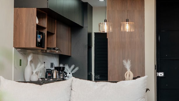 Un salon moderne avec un canapé, un ventilateur de plafond et des luminaires suspendus.