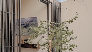 Un espace extérieur aménagé avec des sièges, un hamac, un arbre en pot et une table.
