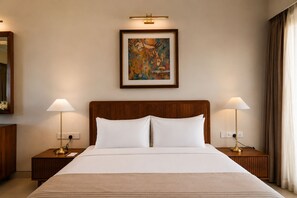 A hotel room with a large bed, two bedside lamps, a framed artwork above the bed, and a mirror on the left wall. - Rekawa Reach Tangalle (Rekawa)