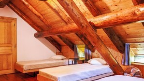 A wooden attic bedroom with two beds, a wooden ceiling, and a window. - Rustico Grace by Interhome (Malvaglia)