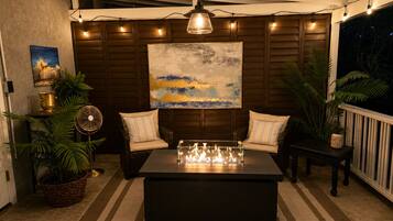 A cozy indoor seating area with a table, chairs, and a fan.