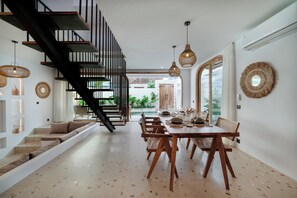 A modern interior with a staircase, dining area, and natural light. - Cadaques Villa by Betterplace (Ungasan)