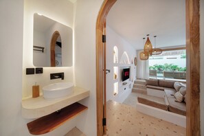 Ein modernes Badezimmer mit einer freistehenden Badewanne, einem großen Spiegel und einem integrierten Waschbecken.
