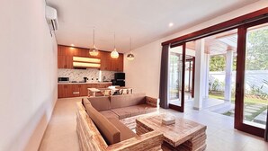 A modern interior with a kitchen, dining area, and a large sliding glass door leading to an outdoor space. - Private Two Bedroom Pool Villa, Spacious Garden and Tranquil (Ubud)