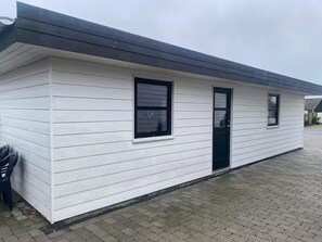 A single-story building with a flat roof, a front door, and two windows. - 4 Star Holiday Home in Otterup (Otterup)