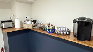 Eine Küchenzeile mit Toaster, Wasserkocher und Kaffeemaschine.