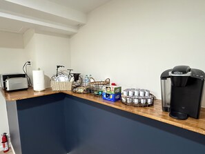 Eine Küchenzeile mit Toaster, Wasserkocher und Kaffeemaschine.