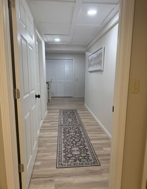 A hallway with a patterned rug, white doors, and a ceiling light. - The Modern Garden Suite: With Private Entrance ~ 1 BR - sleeps 3 (Manchester)