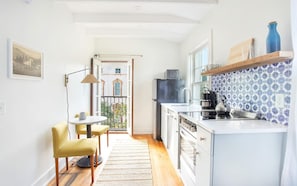 Eine moderne Küche mit Essbereich, Blick auf einen Balkon und einer gemusterten Spritzschutzwand.