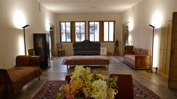 Ein geräumiges Wohnzimmer mit einem großen Bett, einem Sofa, einem Couchtisch und einem Kamin.